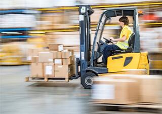 Warehouse worker driving forklift